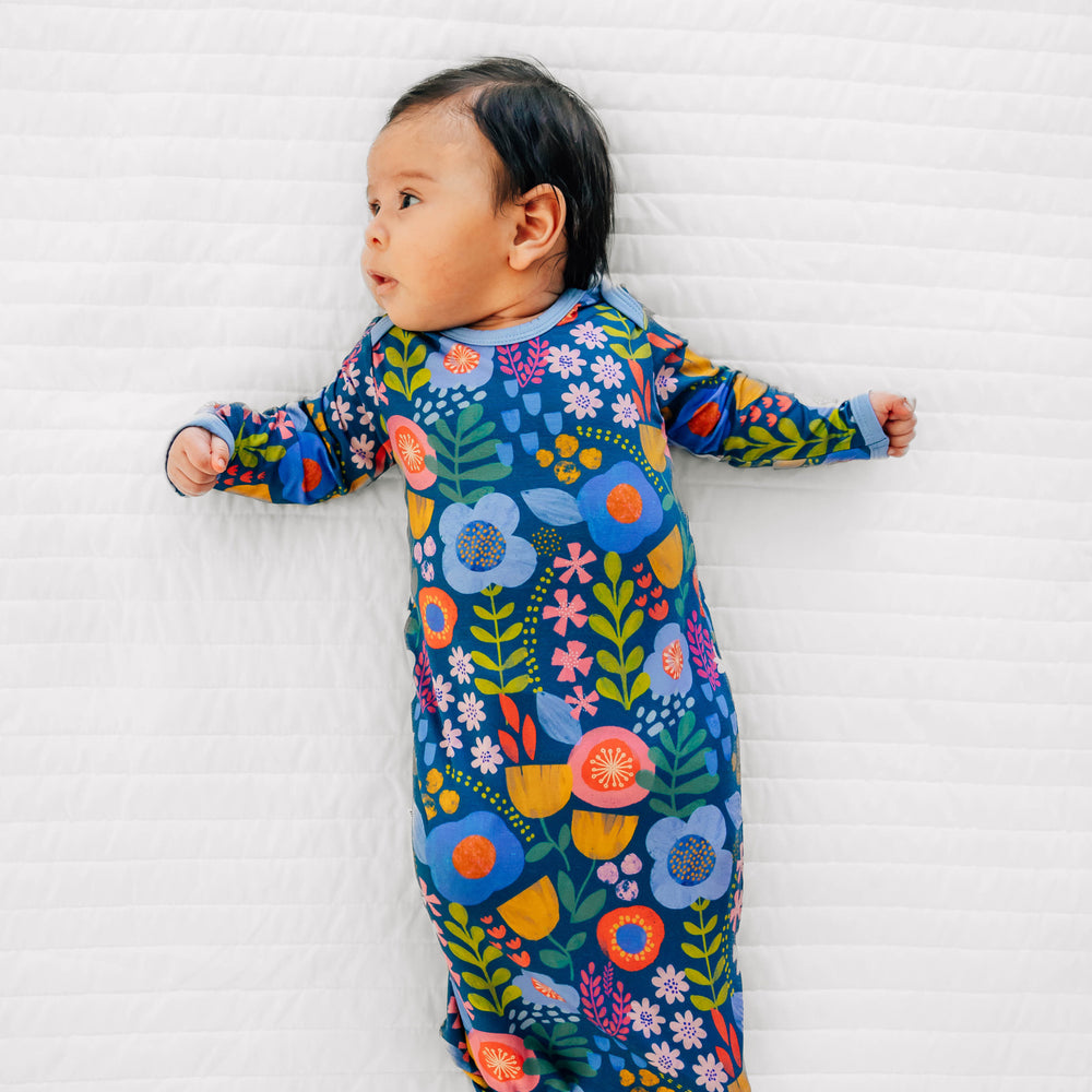 Baby laying down in the Folk Floral Infant Gown