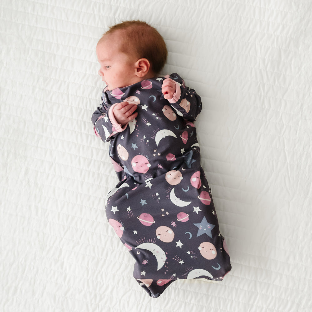 Child laying on a bed wearing a Pink to the Moon and Back Infant Gown