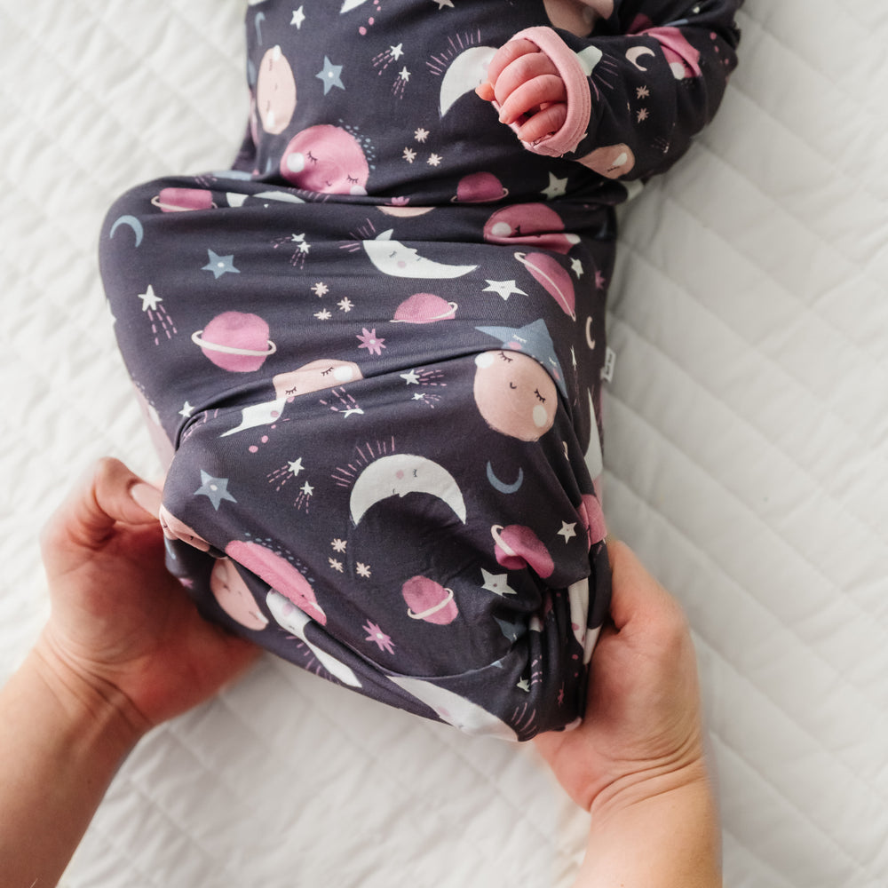 Alternate image of a child laying on a bed wearing a Pink to the Moon and Back Infant Gown demonstrating the fold over bottom