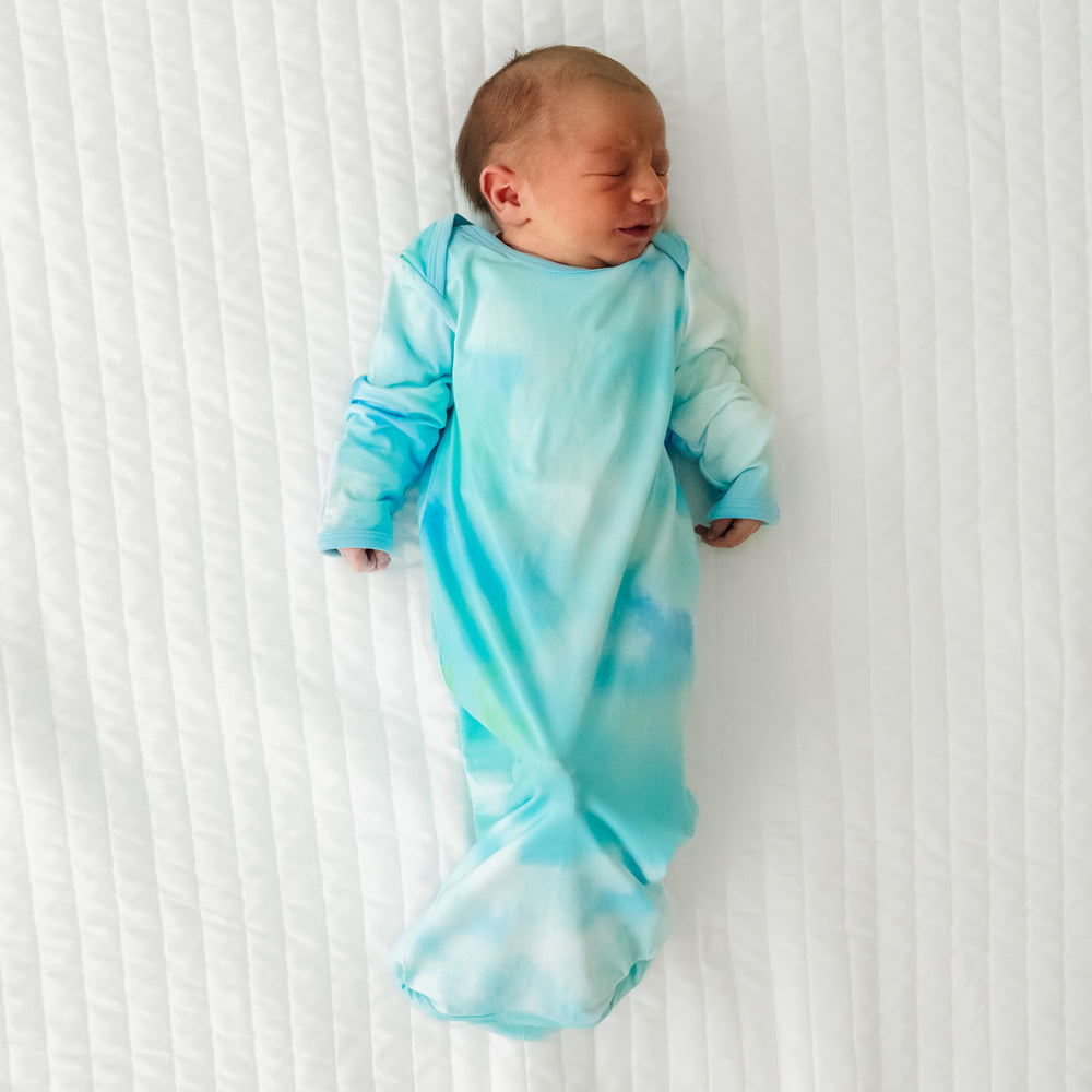 Child laying on a bed wearing a Tidepool Infant Gown