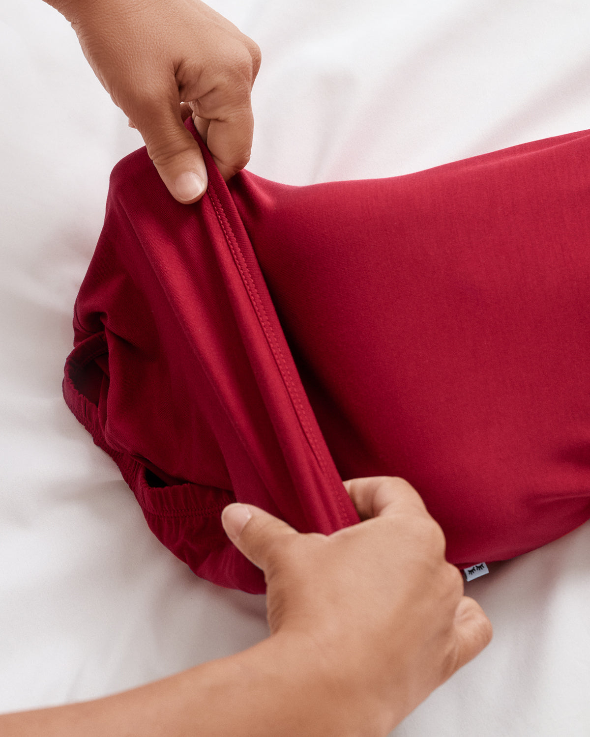 A close-up of a person's hands adjusting the infant gown. 
