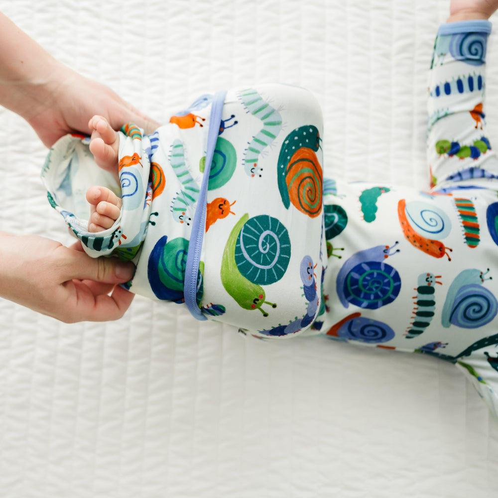 Close up image of an infant wearing an Inchin' Along infant gown with a parent folding over the bottom