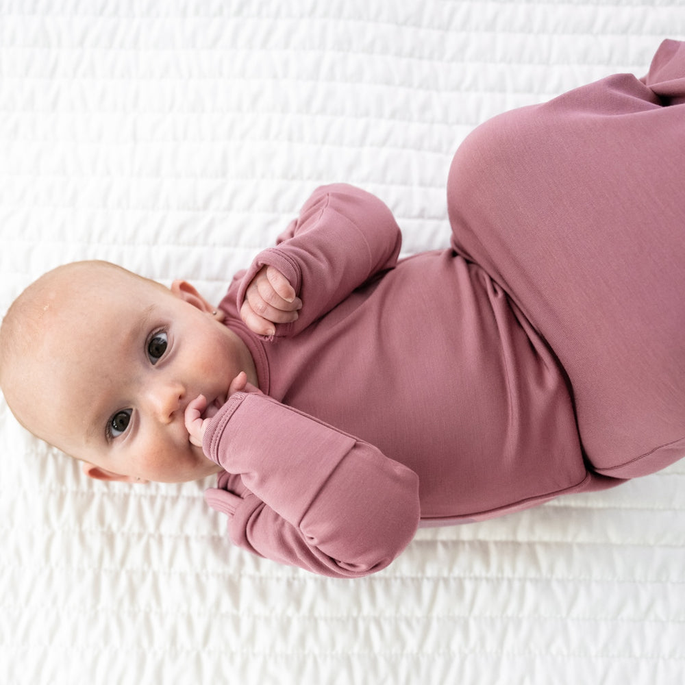 Alternate image of a child laying on a bed wearing a Cozy Dusty Plum infant gown