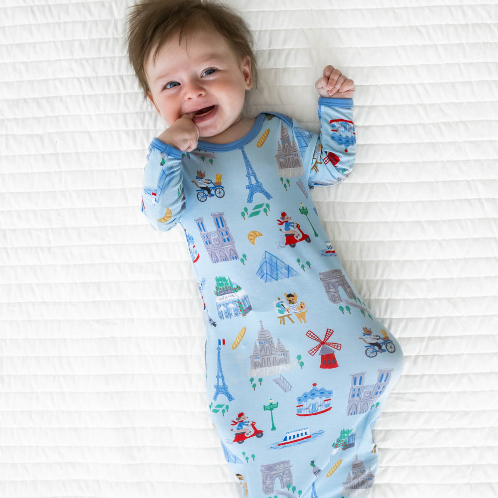 Top view image of baby laying down wearing the Blue Weekend in Paris Infant Gown