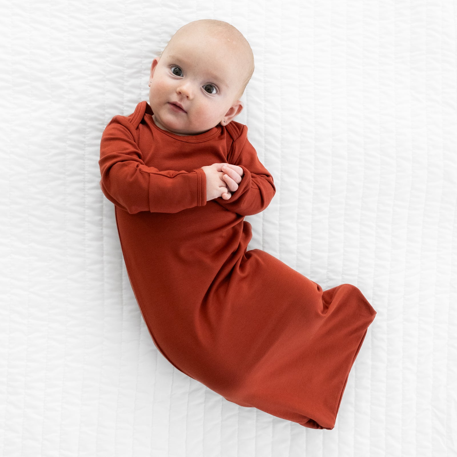 Child wearing a Cozy Rust infant gown