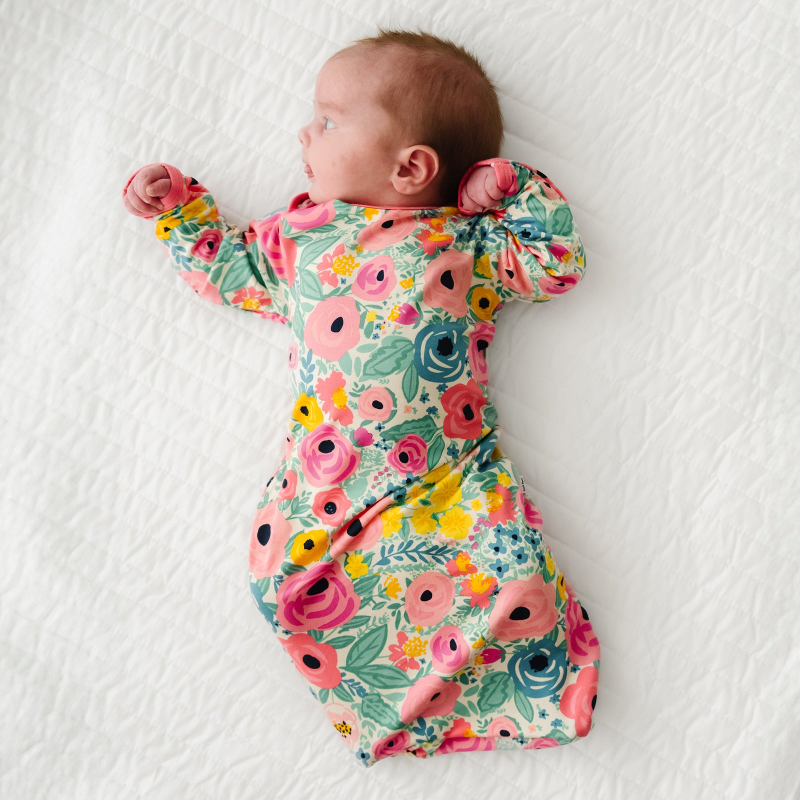 Child laying on a bed wearing a Secret Garden Infant Gown