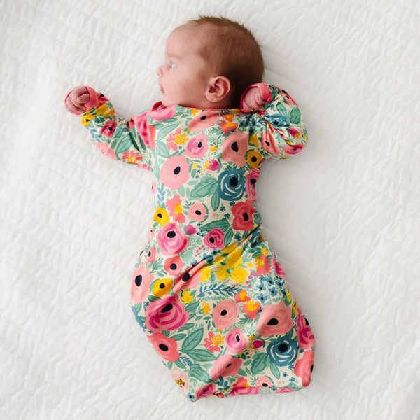 Child laying on a bed wearing a Secret Garden Infant Gown