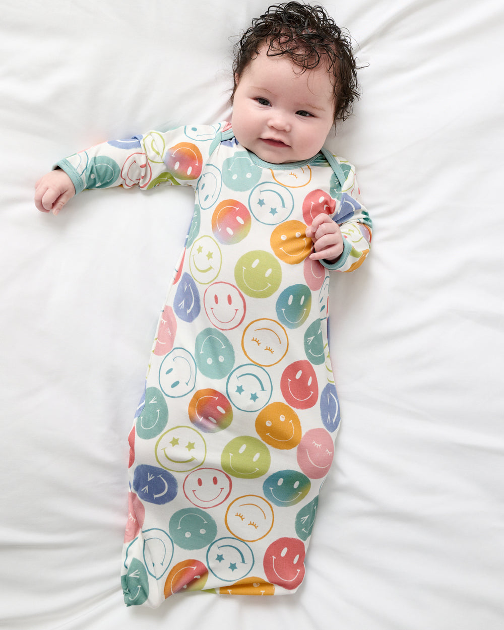 Aerial view of baby wearing the Positive Vibes Infant Gown