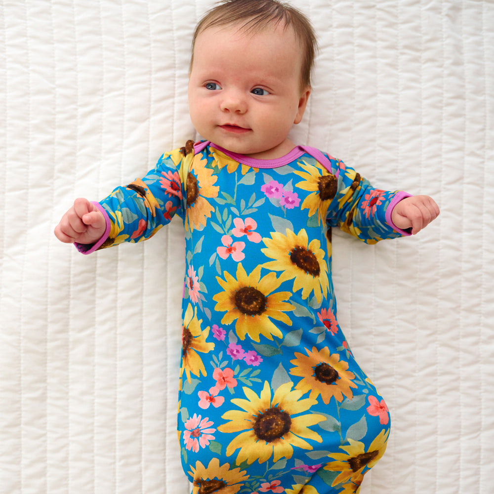 Top view of baby laying down wearing the Sunflower Fields Infant Gown