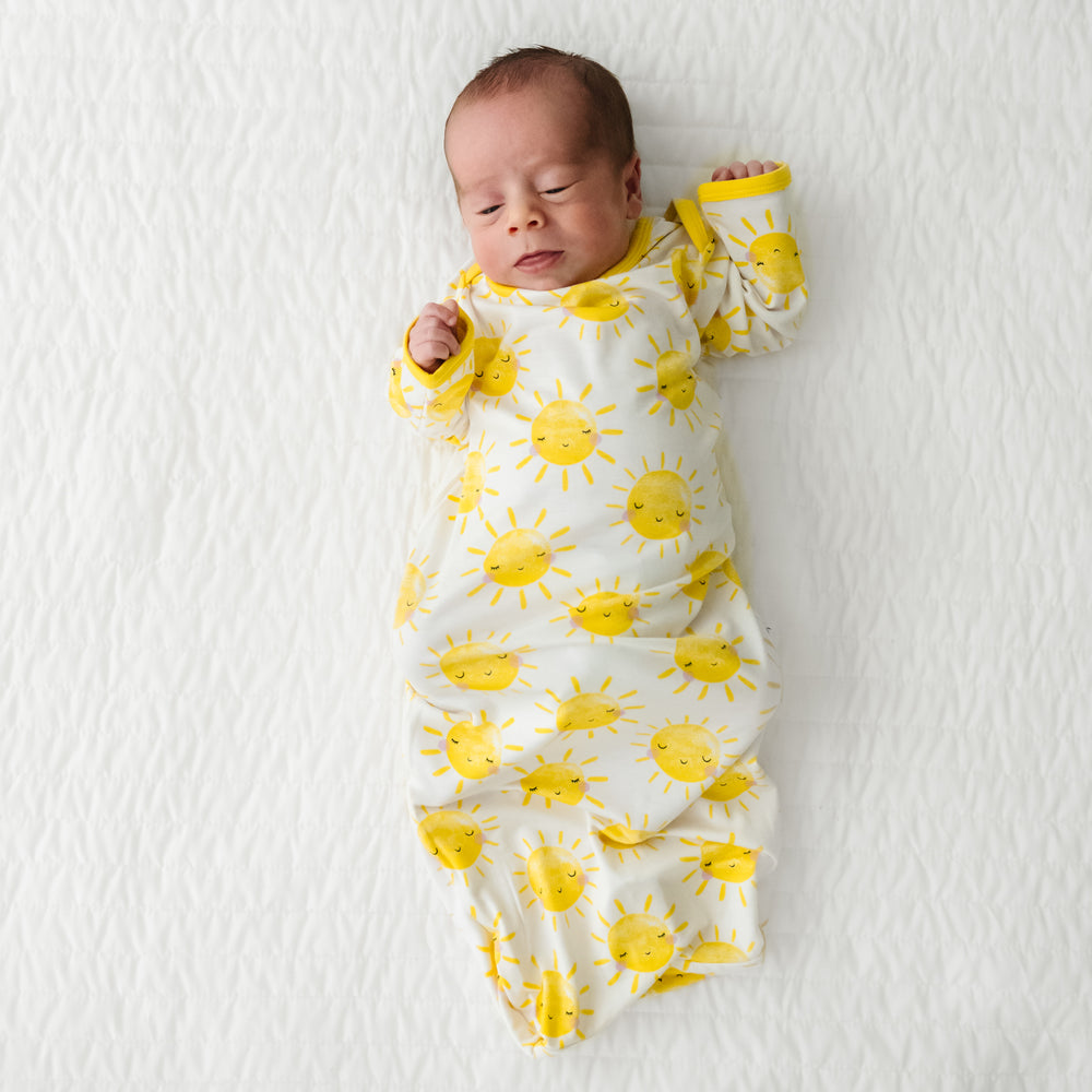 Child laying on a bed wearing a Sunshine Infant Gown