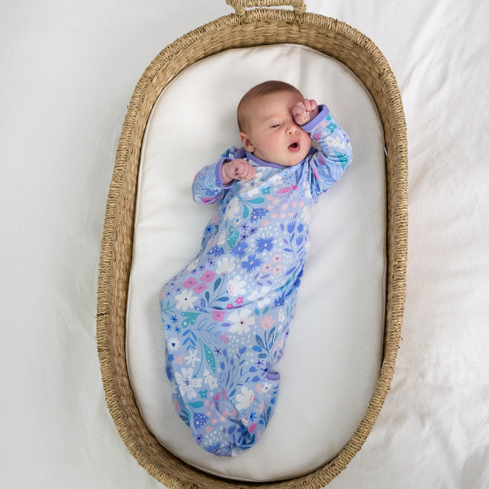 Child laying in a bassinet wearing a Magical Meadow infant gown