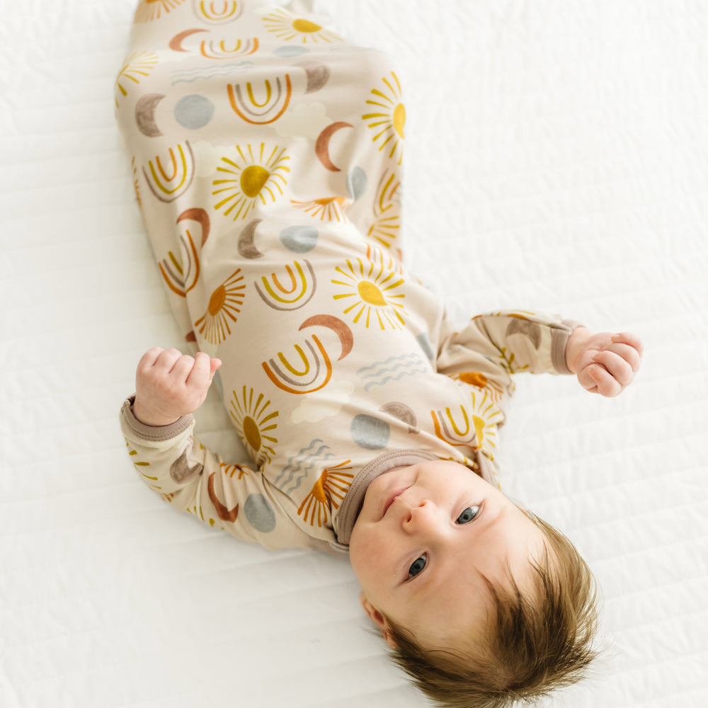 Alternate image of a child laying on a bed wearing a Desert Sunrise infant gown