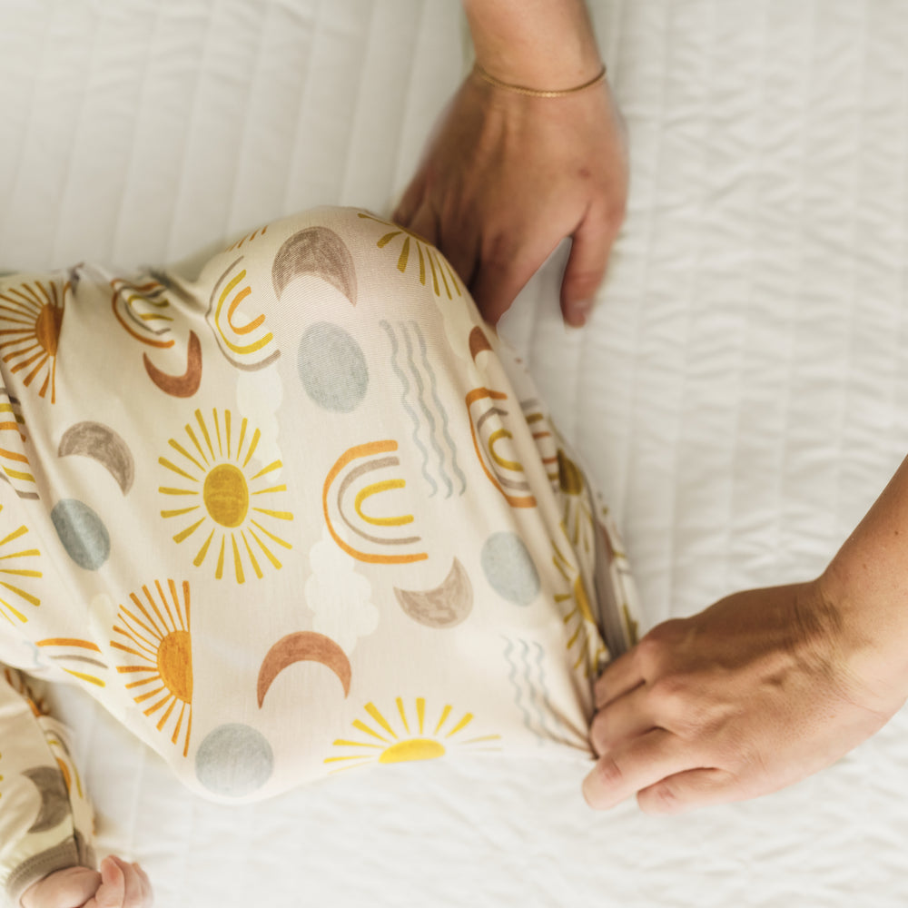 Mother folding over the leg envelope flap on a Desert Sunrise Infant Gown