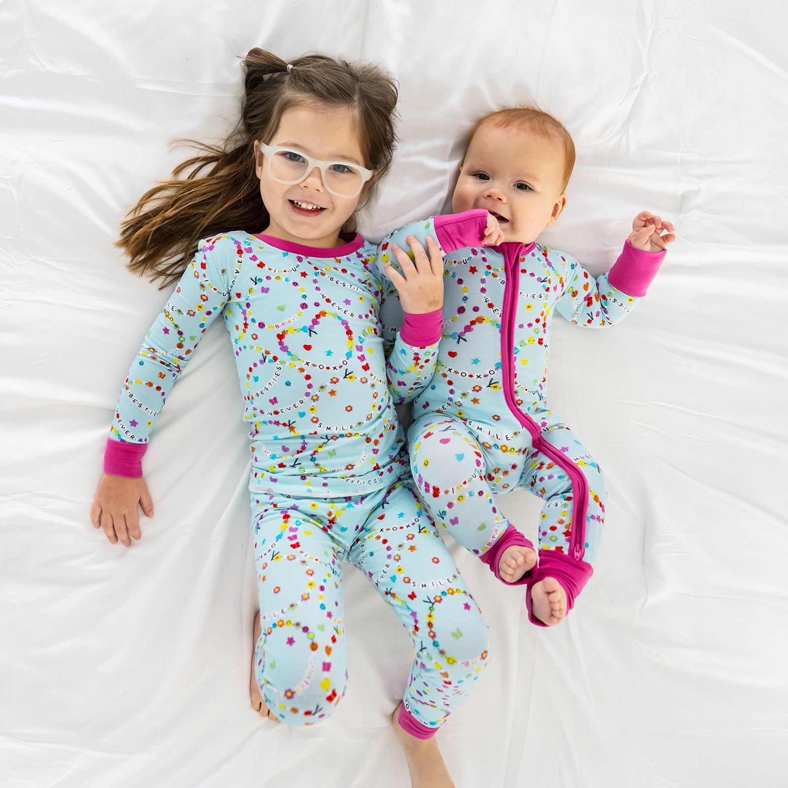 Image of siblings wearing matching Friends Forever pjs. They are wearing the Friends Forever two-piece pj set and the Friends Forever zippy.