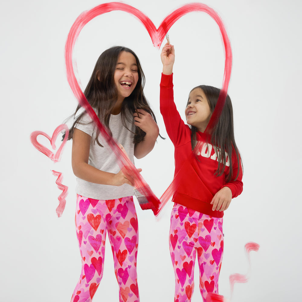 Two children wearing Pink Hearts & Crafts Leggings with coordinating red and white tops