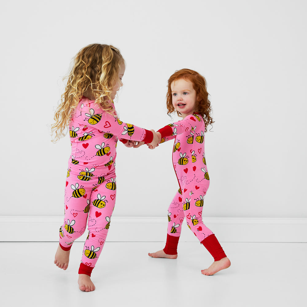 two children holding hands wearing Bee Mine pjs in two piece and zippy styles