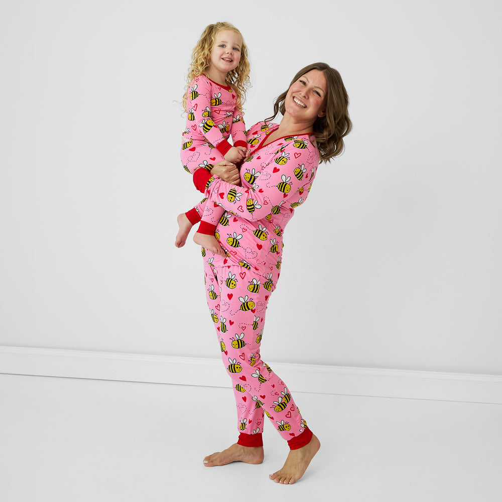 Mother and daughter embracing wearing Pink Bee Mine pjs in women's and childrens two piece styles