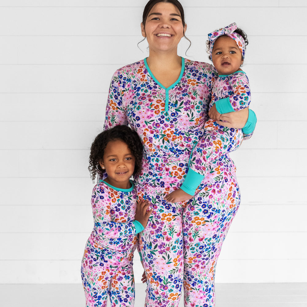 Mother and her two children wearing Sweet Pea Floral pjs. Mom is wearing women's Sweet Pea Floral pjs in women's top and bottom and children are wearing matching two piece and crescent zippy styles