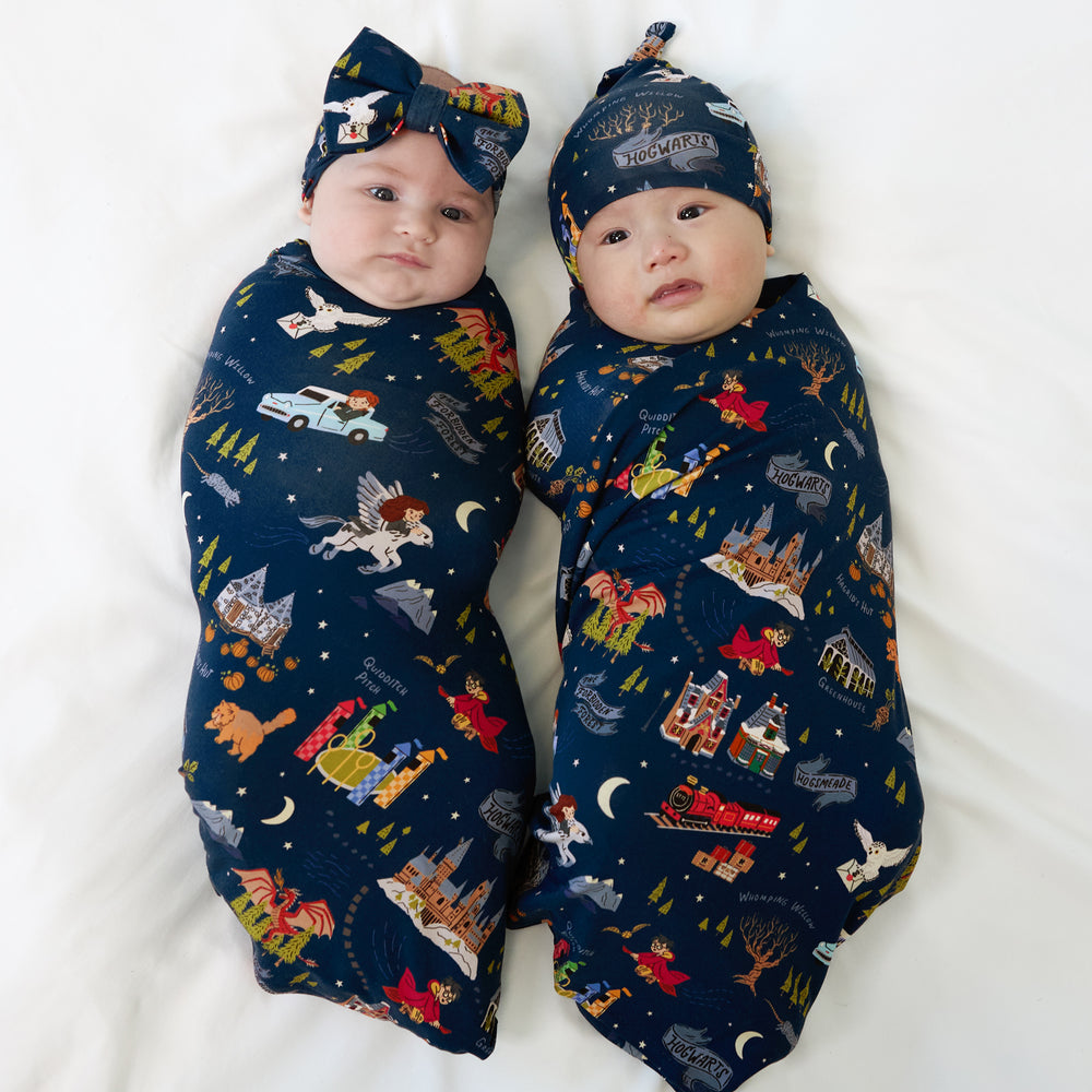 two children swaddled in matching an Evening at Hogwarts swaddle and luxe bow headband set and a hat set