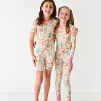 Two girls posing together wearing matching Pink Ready To Rodeo pjs in two piece and two piece shorts and short sleeve styles
