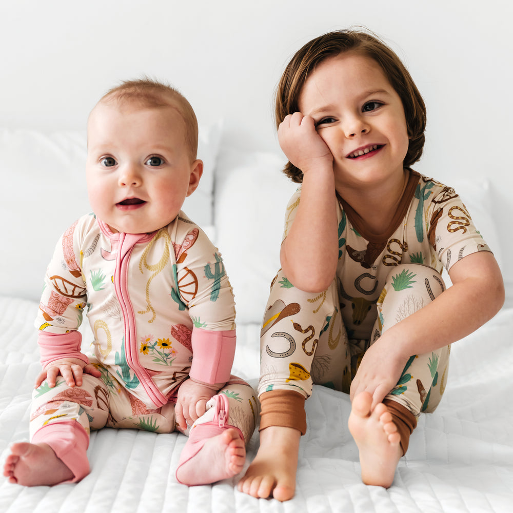 two children posing together wearing matching pink an caramel Ready to Rodeo Zippies