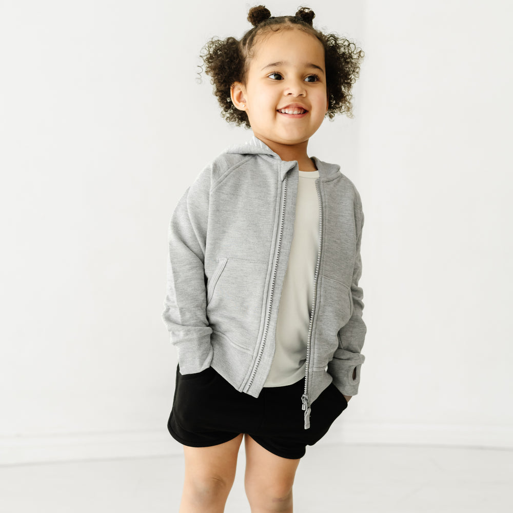 Child wearing Black dolphin shorts and coordinating Play top and zip hoodie