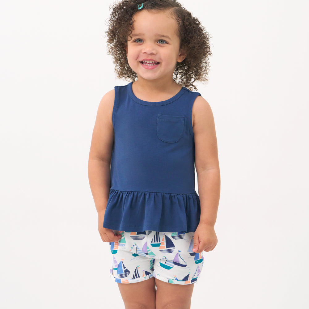 Child wearing Seas the Day dolphin shorts paired with a Vintage Navy peplum top