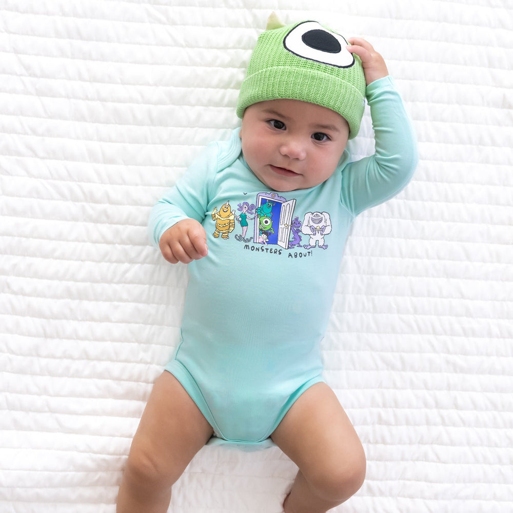 Top view image of baby laying down while wearing the Disney Monsters, Inc. Mike Wazowski Beanie Hat and Disney Monsters, Inc. Graphic Bodysuit