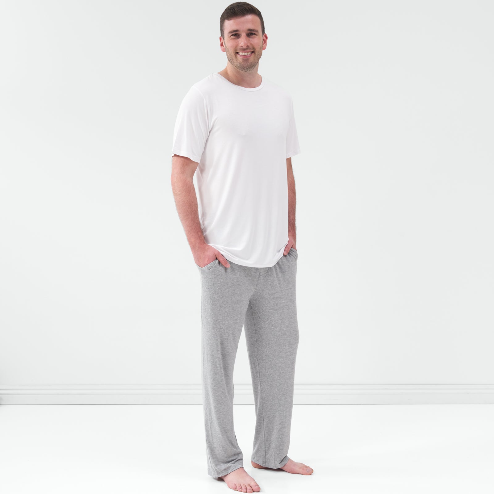 Man wearing the Bright White Men's Short Sleeve Pajama Top with gray pajama pants