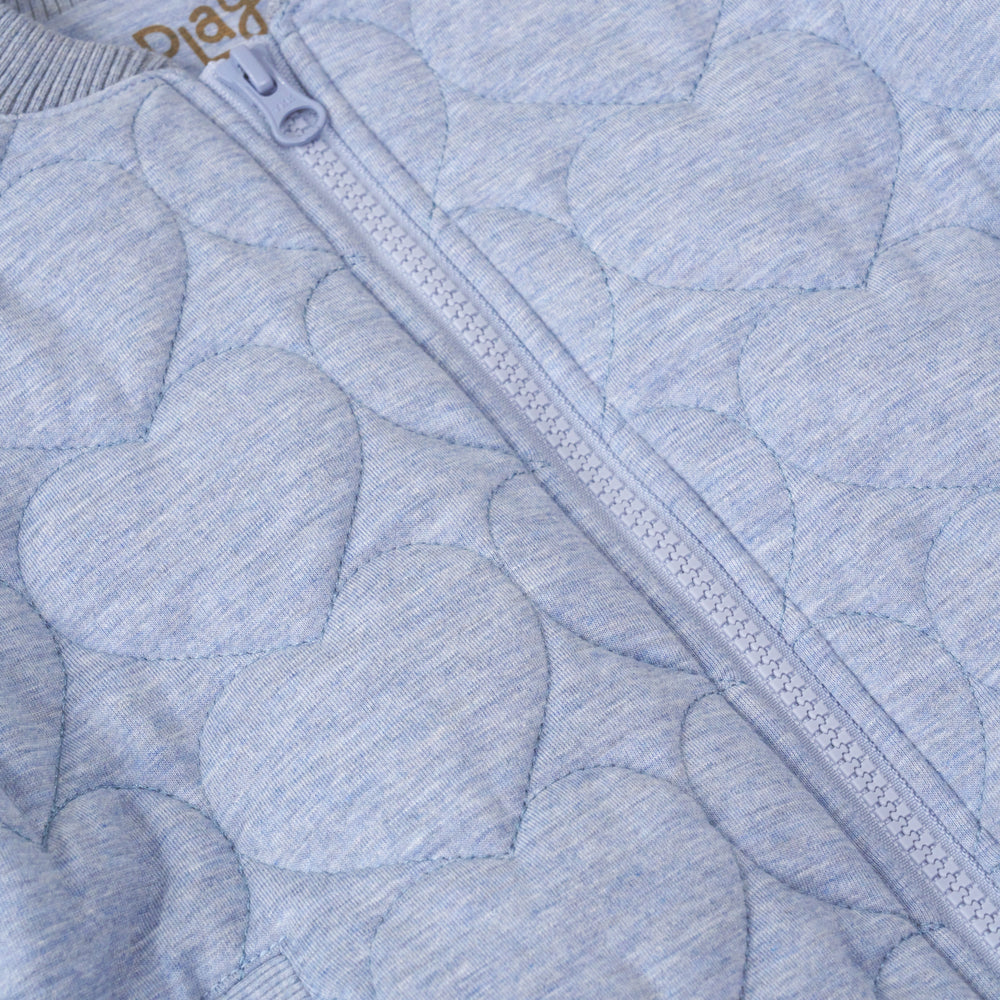 close up view of the zipper on a light blue denim quilted varsity jacket