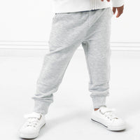 Close up image of a child posing wearing Light Heather Gray joggers