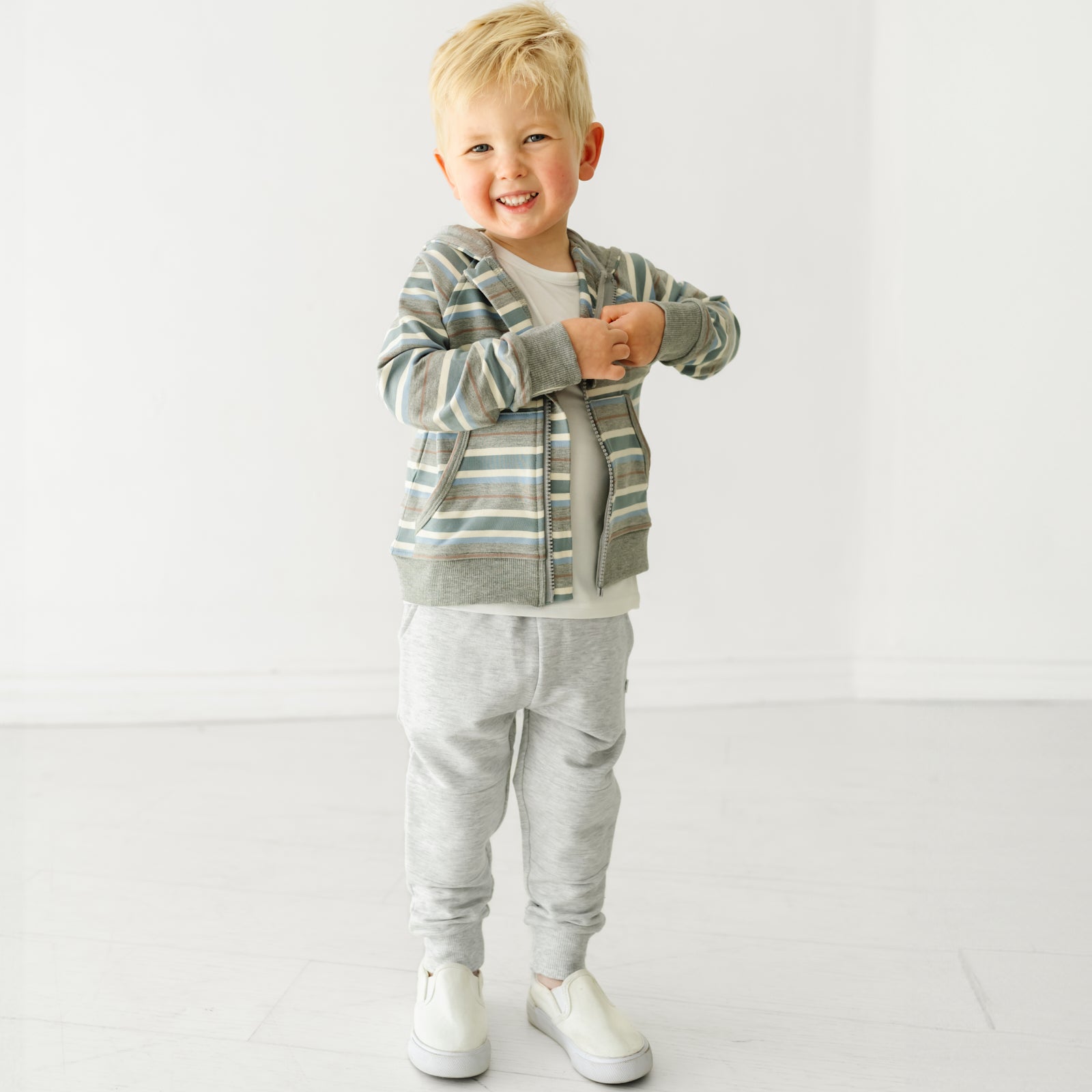 Child wearing Light Heather Gray joggers and coordinating Play top and zip hoodie
