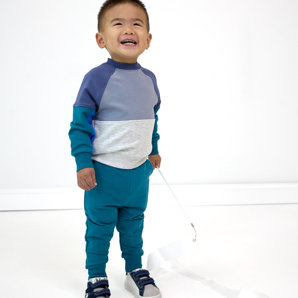 Smiling boy wearing the Glacier Blue Jogger and Windy Sky Panel Crewneck