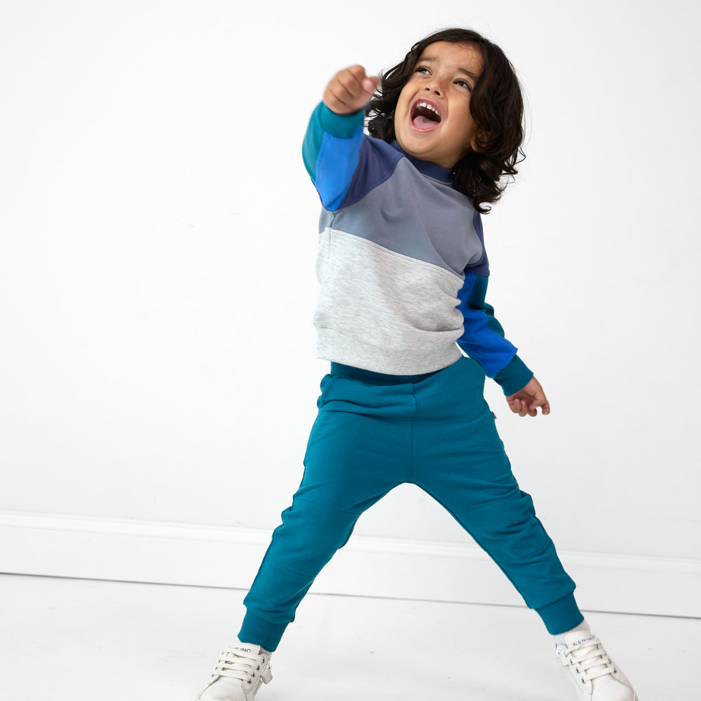 Boy posing while in the Glacier Blue Jogger and Windy Sky Panel Crewneck