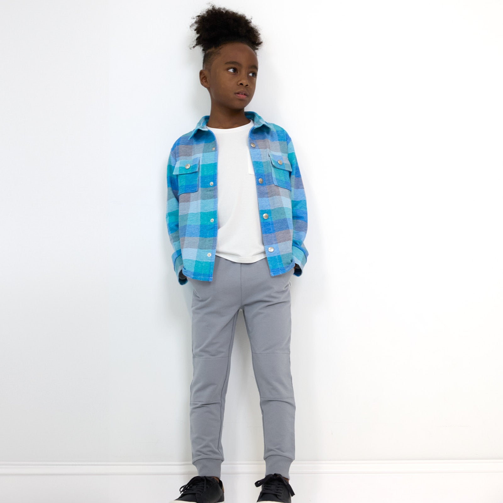 Boy posing with hands in the pockets of the Windy Sky Jogger while wearing the Arctic Plaid Shacket