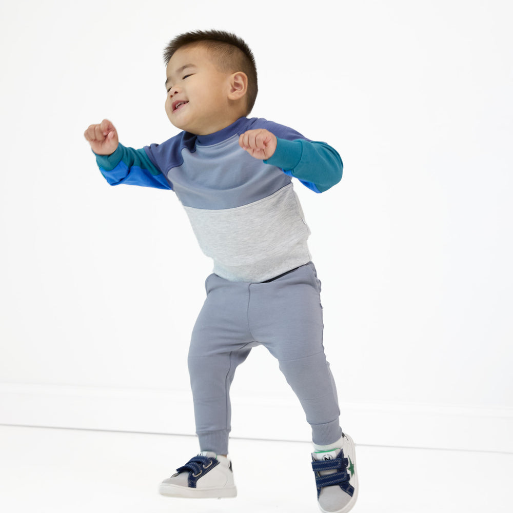 Boy posing and dancing while wearing the Windy Sky Jogger and Windy Sky Panel Crewneck