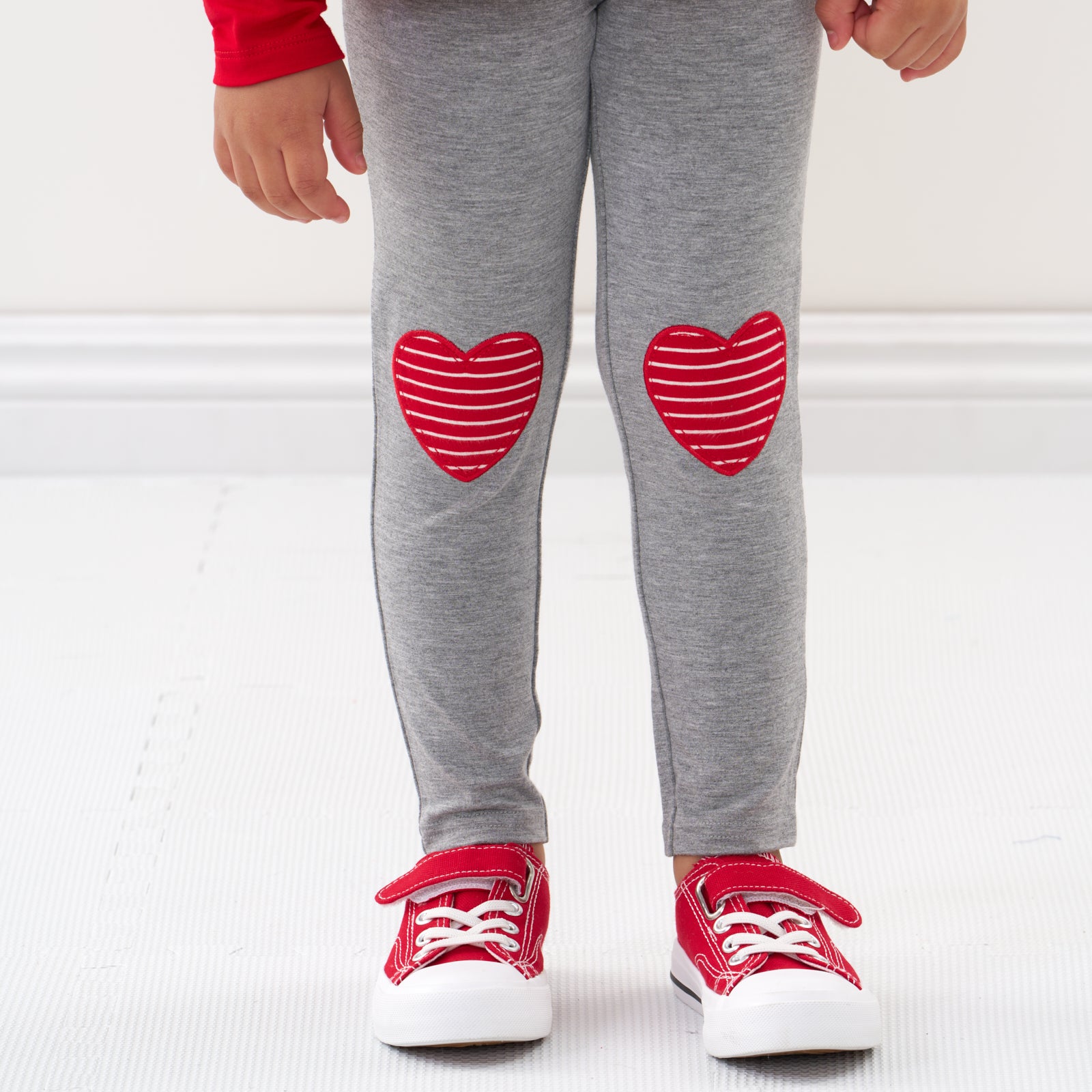 Close up image of a child wearing Heart Patch leggings detailing the patches