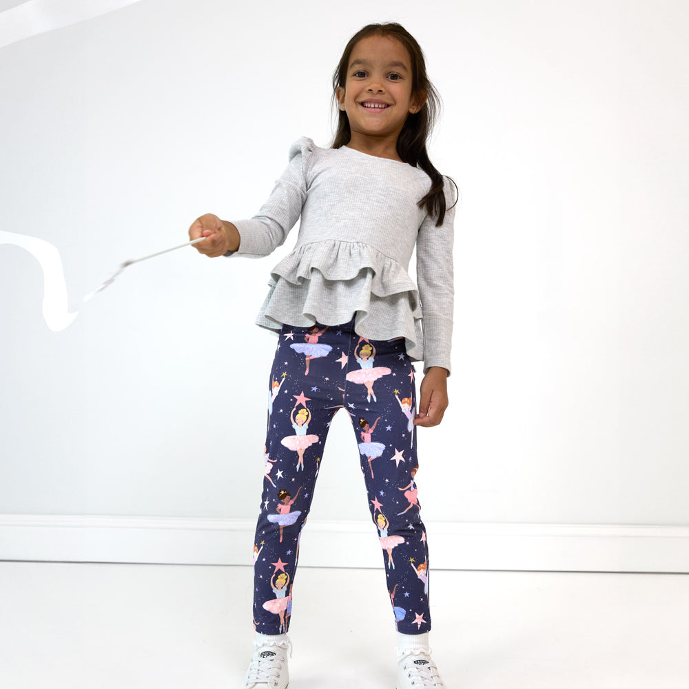 Smiling girl playing with a streamer while wearing the Twilight Ballet Legging and Light Heather Gray Peplum Top