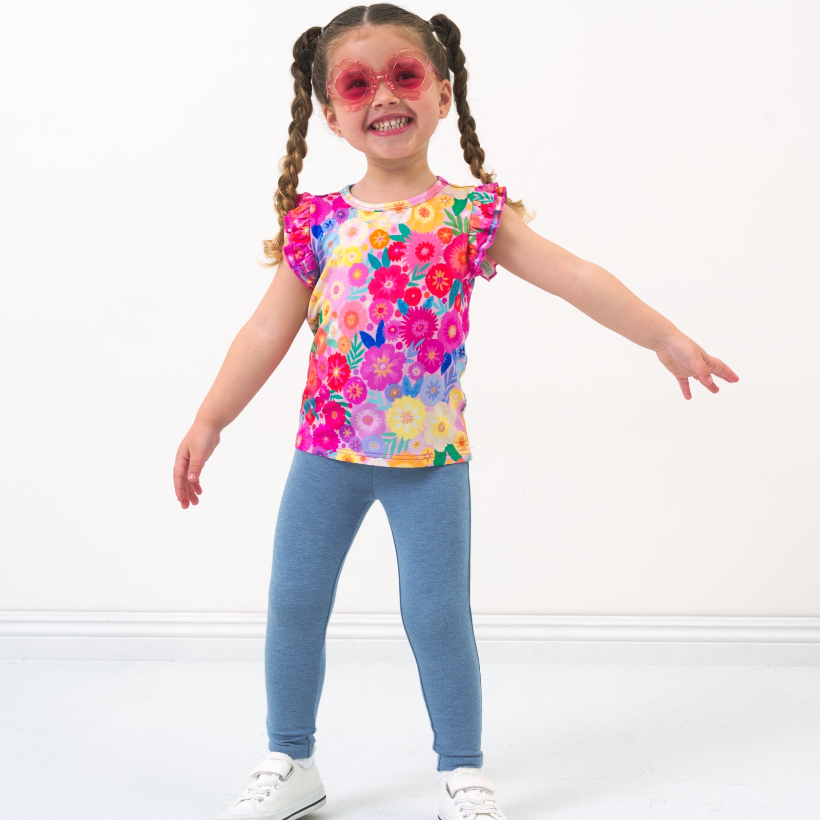 Child wearing Heather Blue leggings paired with a Rainbow Blooms flutter tee shirt