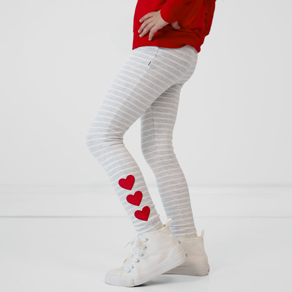 Close up side view of a child wearing Heart Patch Leggings