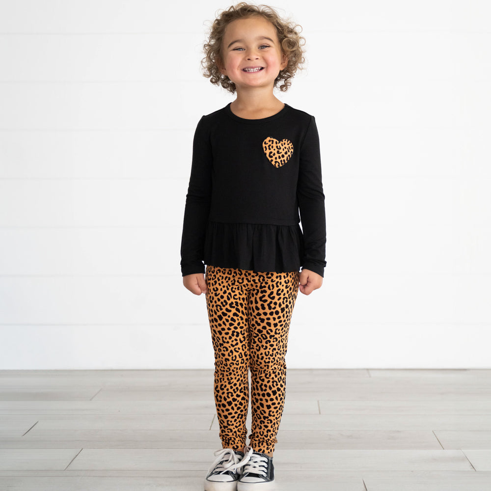 Girl wearing the Classic Leopard Legging & Classic Leopard Long Sleeve Pocket Peplum Tee