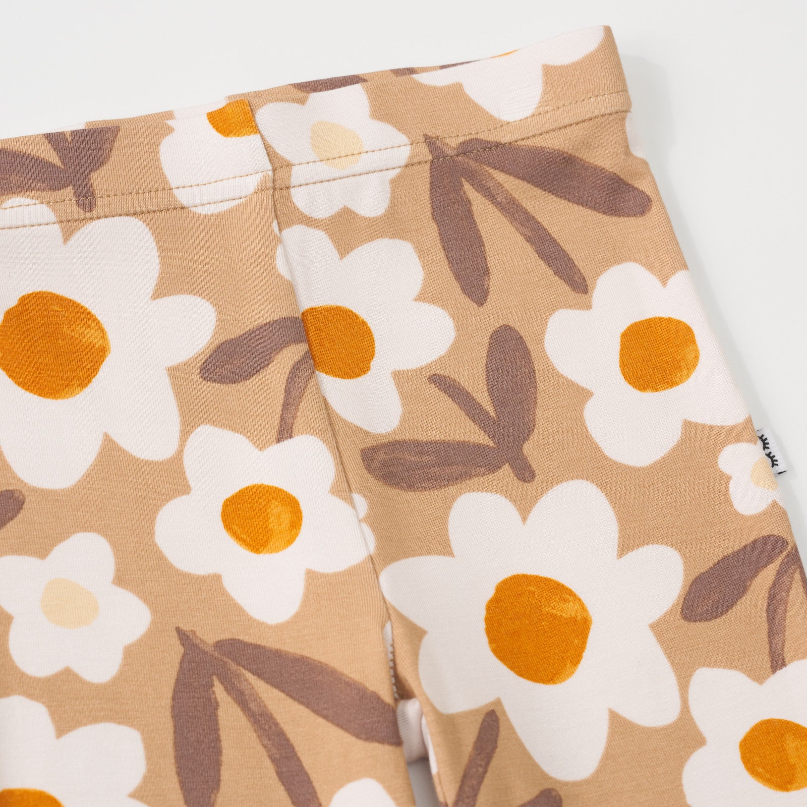 Close-up view of the tan floral print on a Daisy Daydream legging