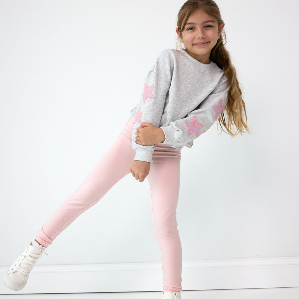 Girl posing while wearing the Prima Pink Legging and Light Heather Gray Drop Shoulder Crewneck