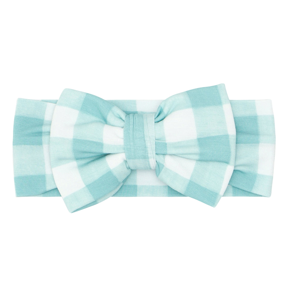 Click to see full screen - Flat lay image of an Aqua Gingham luxe bow headband in size newborn to age four