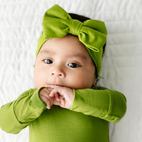 Close up image of a child wearing an Avocado luxe bow headband