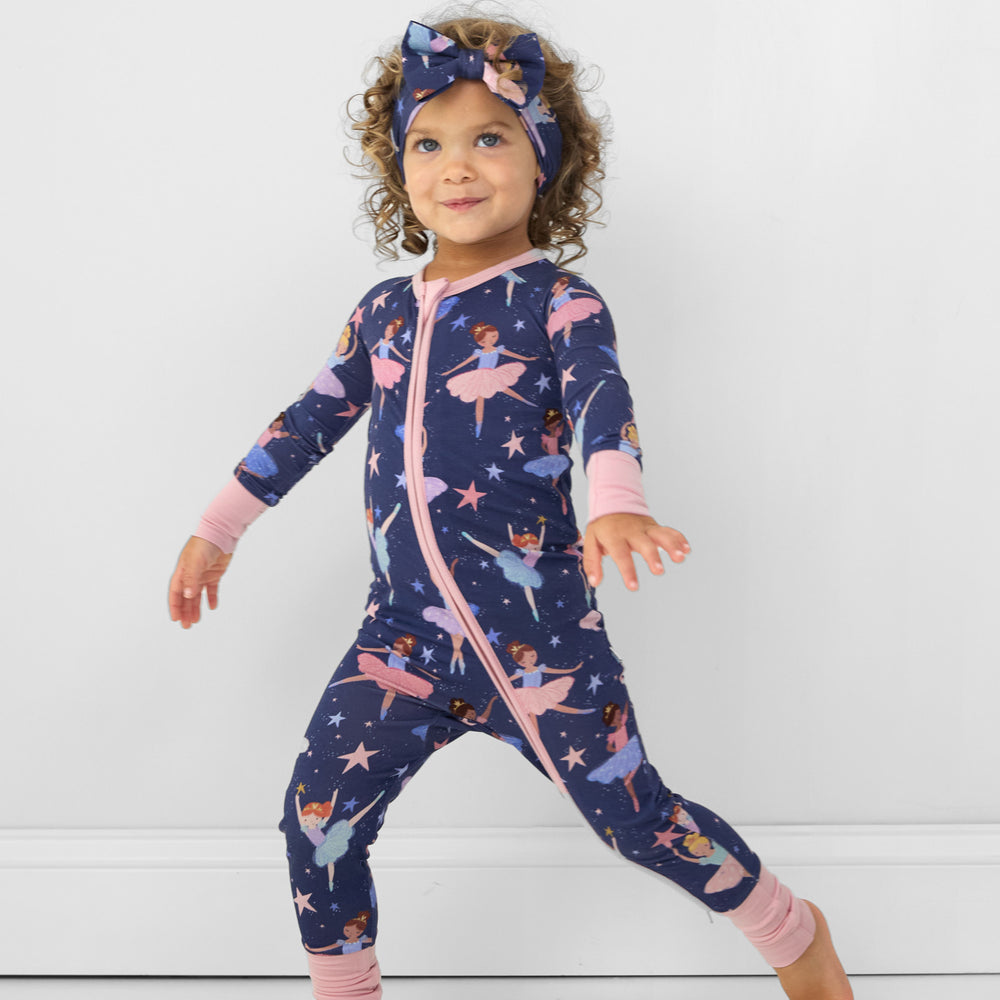 Image of a child posing wearing a Twilight Ballet luxe bow headband and matching zippy