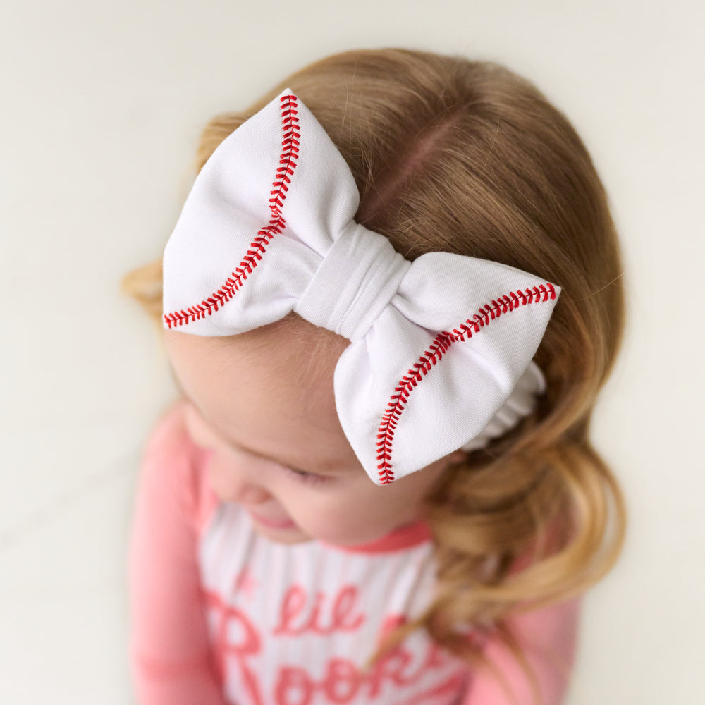 close up image of a child wearing a Baseball luxe bow headband