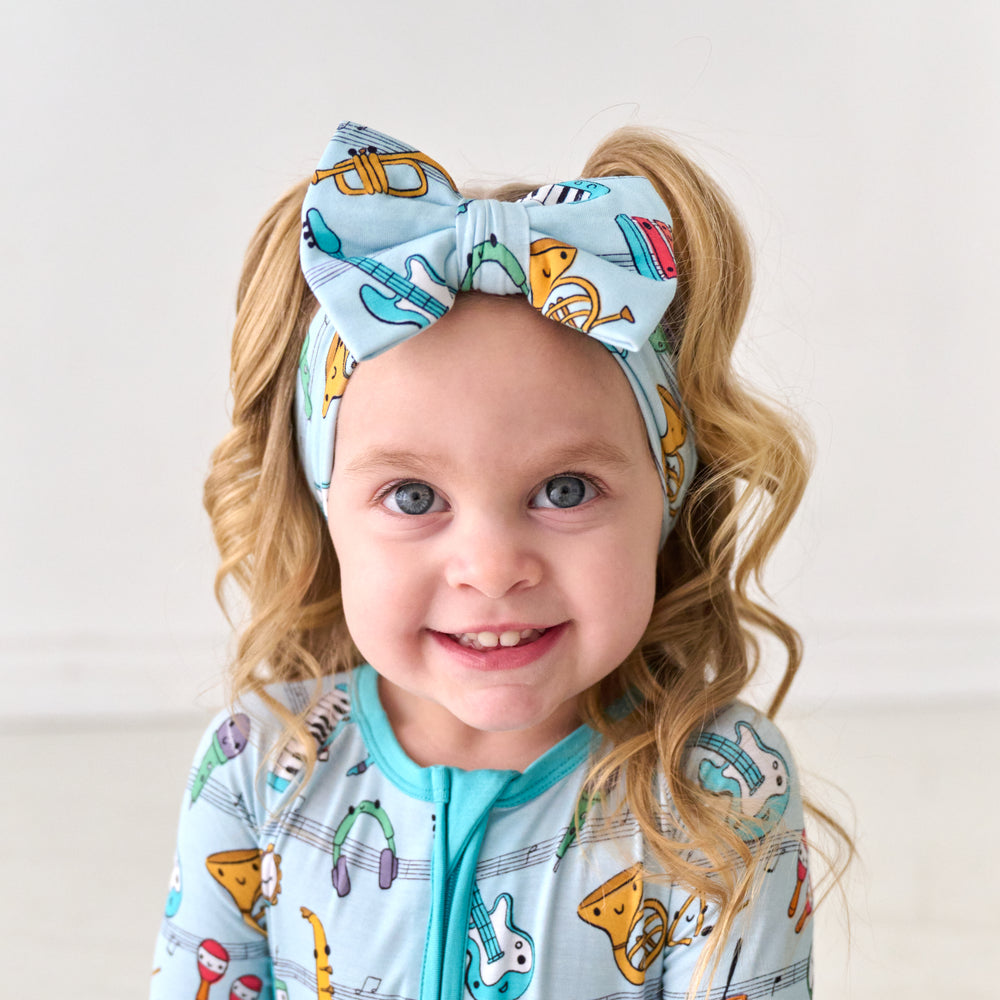 Child wearing a Play Along luxe bow headband and matching pajamas