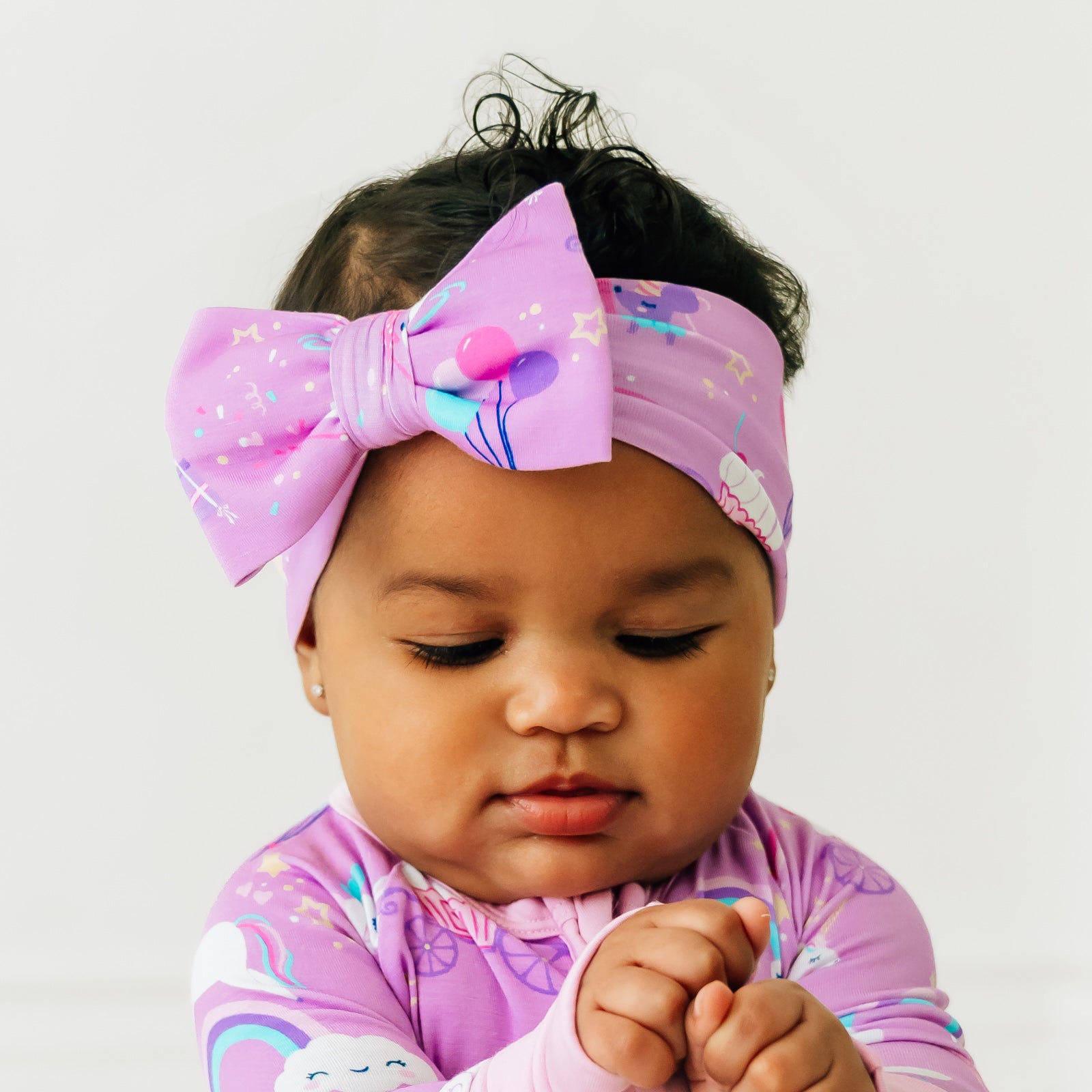 Close up image of a child wearing a Magical Birthday luxe bow headband
