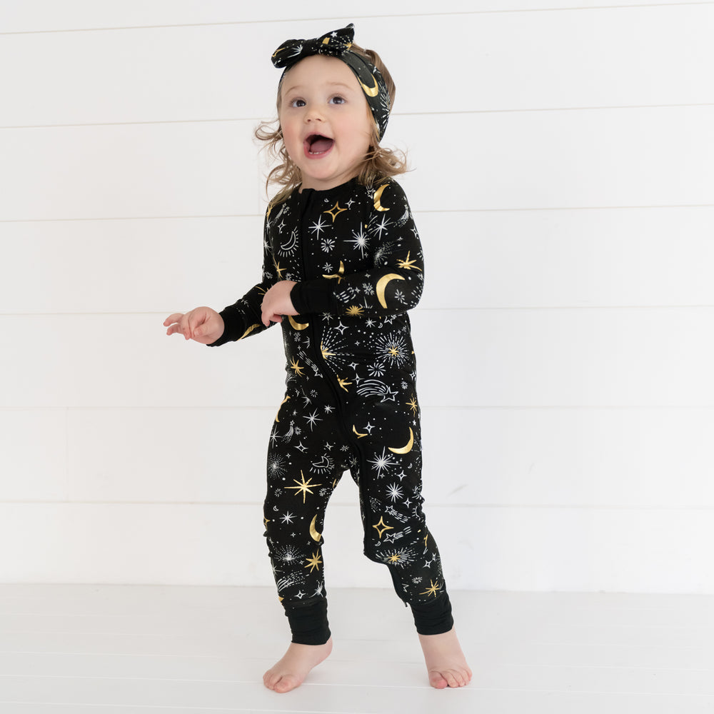 image of a child wearing a Celebration Stars luxe bow headband and matching zippy